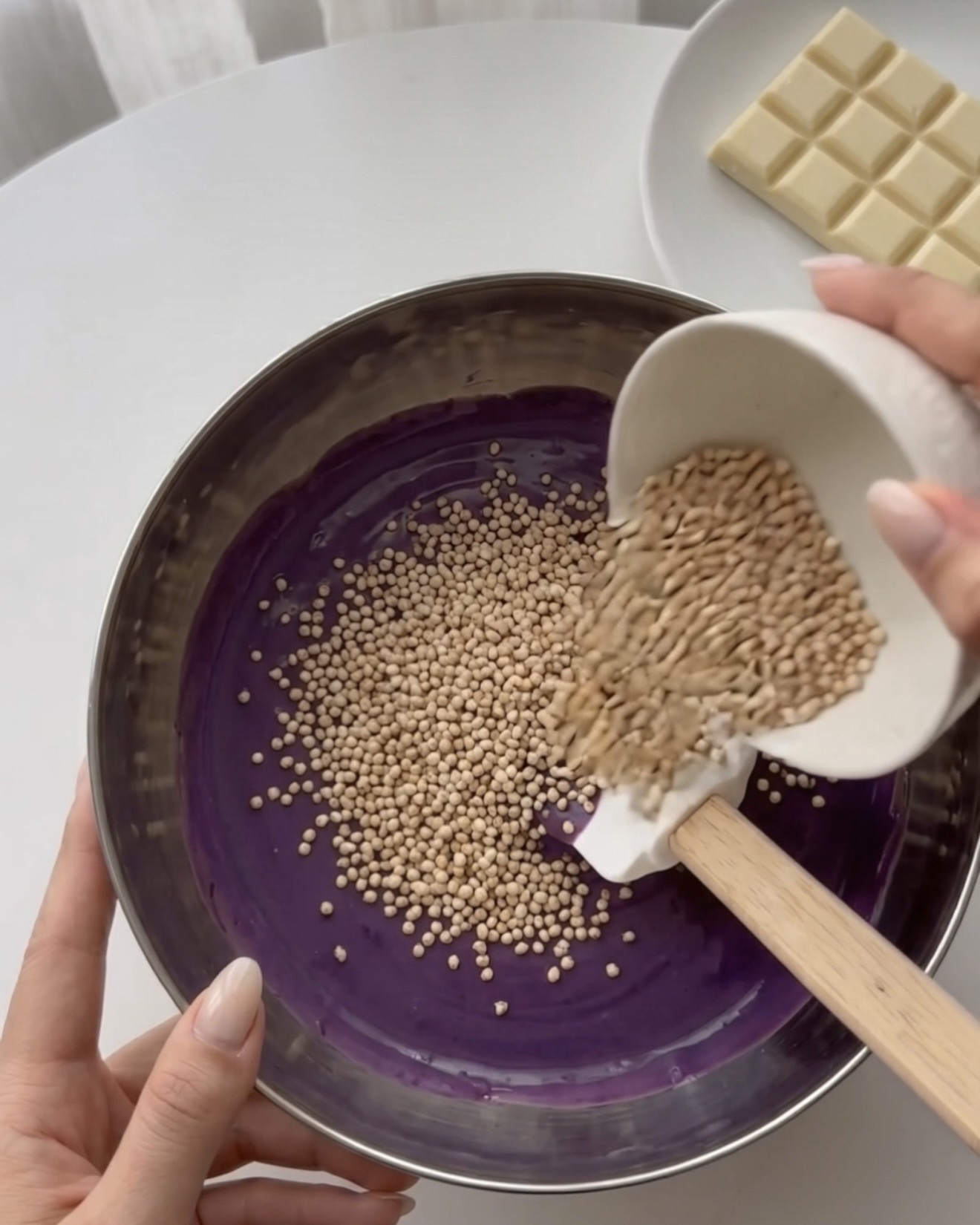 Incorporare la quinoa soffiata nel cioccolato bianco all'ube per i bocconcini di quinoa Ube Nolia