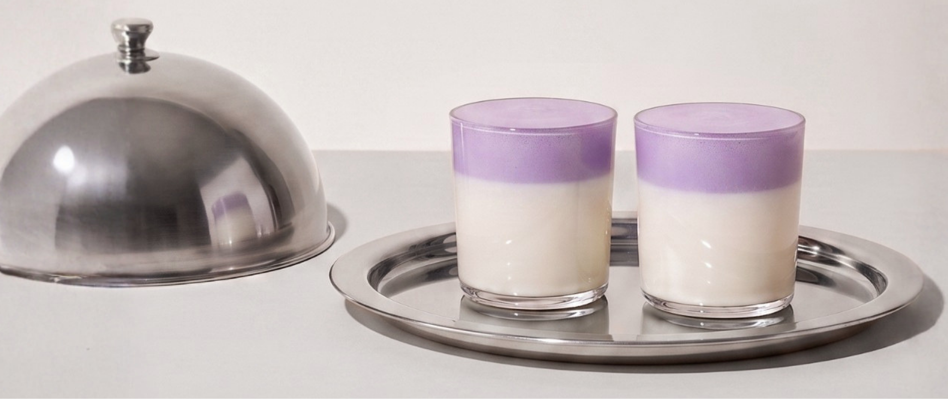Invito al programma fedeltà Ube Nolia con ube latte su un vassoio argentato