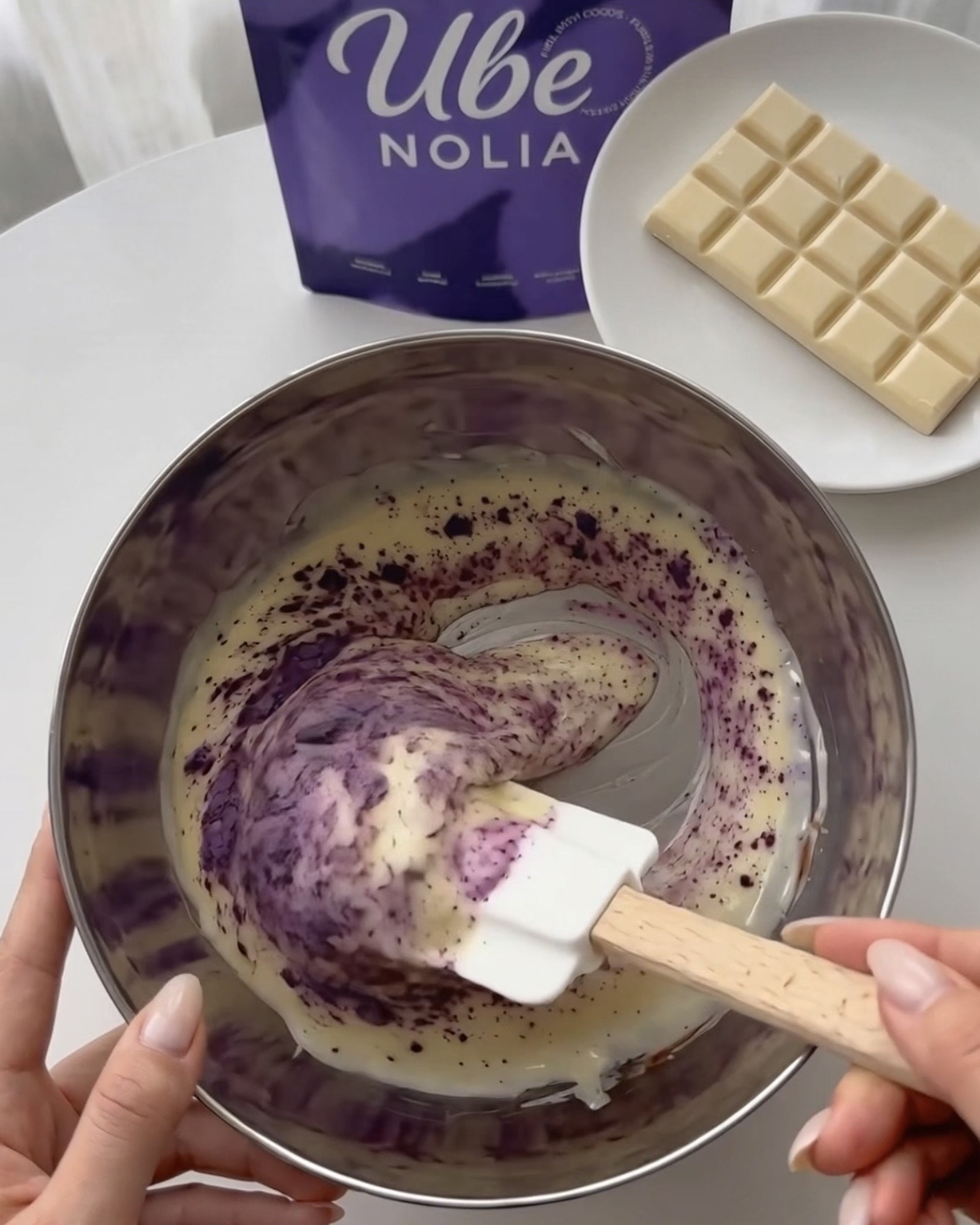 Incorporare Ube Nolia polvere di ube nel cioccolato bianco fuso per i bocconcini di quinoa viola e pistacchio