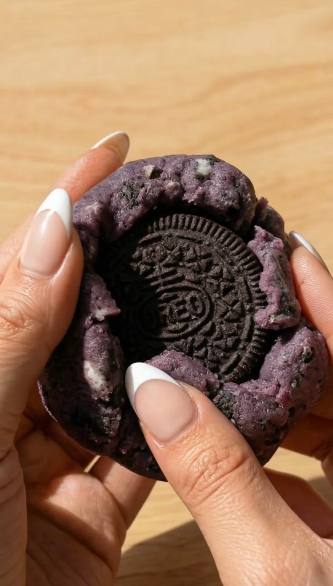 Biscotto ube stile New York spezzato che rivela l'Oreo intero farcito all'interno dell'impasto viola