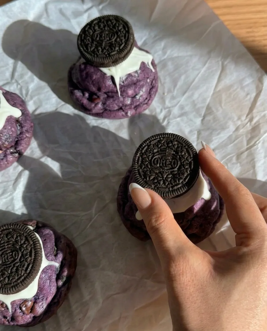 Biscotti Ube Oreo cotti stile New York con Oreo interi pressati sopra e cioccolato bianco che cola