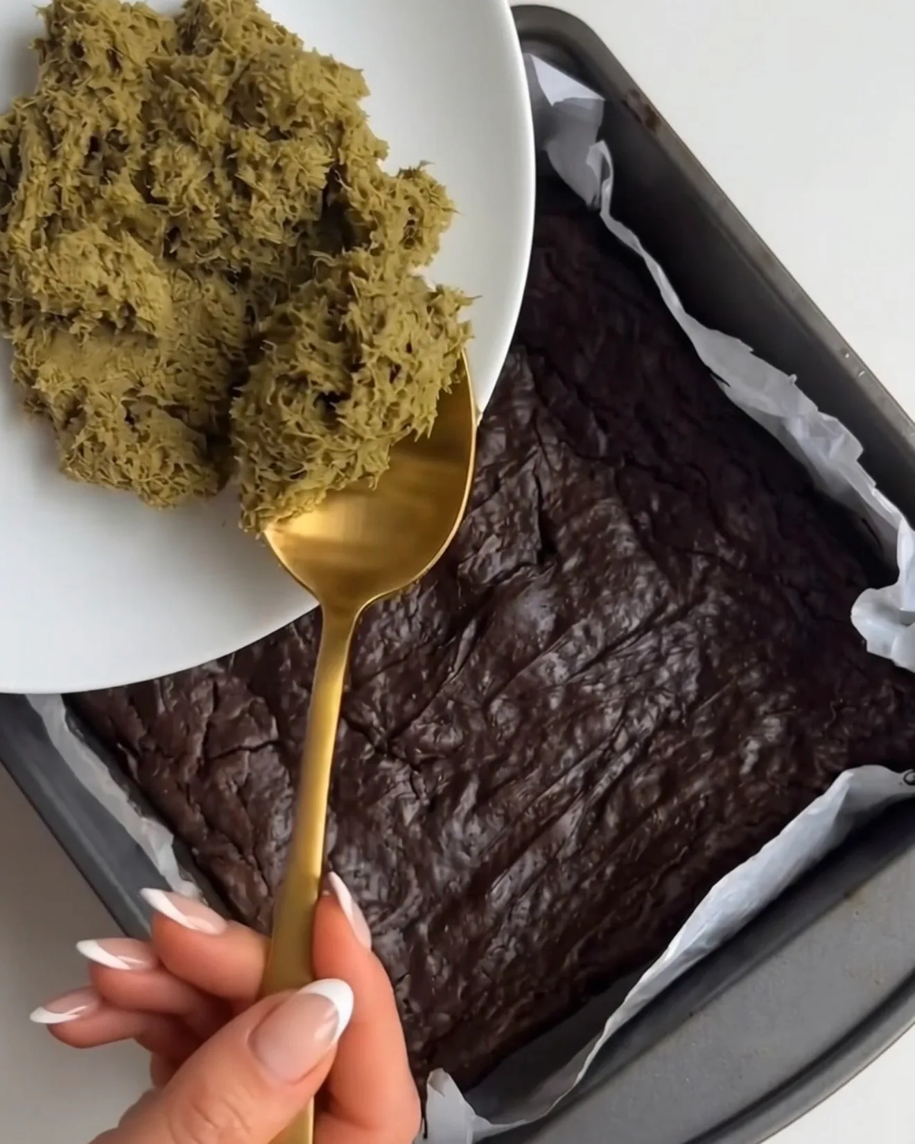 Il ripieno di kataifi al pistacchio viene spalmato sulla base di brownie cotta per le barrette brownie al cioccolato Ube Dubai di Ube Nolia
